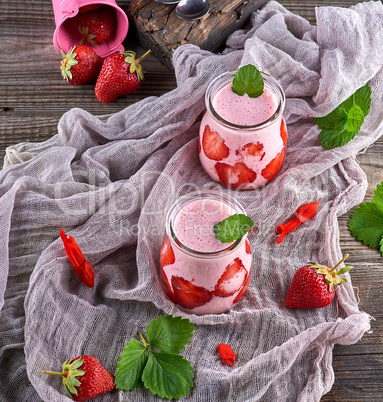 Milk shake with fresh strawberry in glass jars