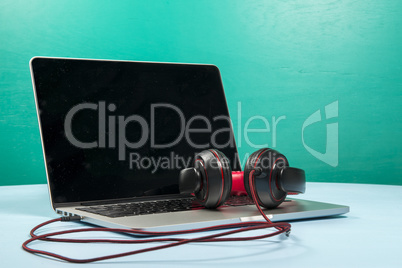 Red earphone on a notebook with a light blue background