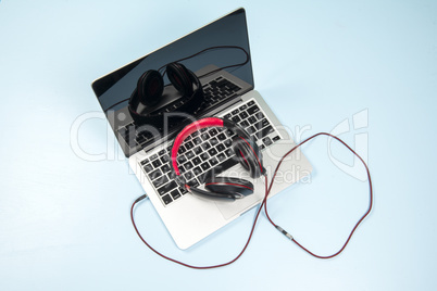 Red earphone on a notebook with a light blue background