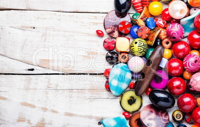 Colorful beads on wooden surface