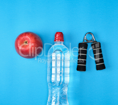 plastic water bottle, red ripe apple and sports expander