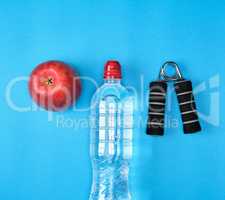plastic water bottle, red ripe apple and sports expander