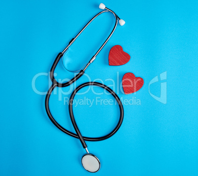 black medical stethoscope and wooden red heart