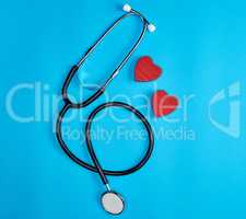 black medical stethoscope and wooden red heart