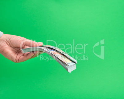 hand holding paper money on a green background