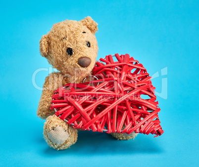 small teddy bear and a red decorative wicker heart