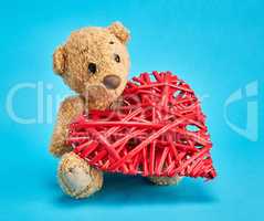 small teddy bear and a red decorative wicker heart