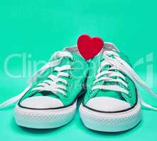pair of green textile sneakers with white untied laces