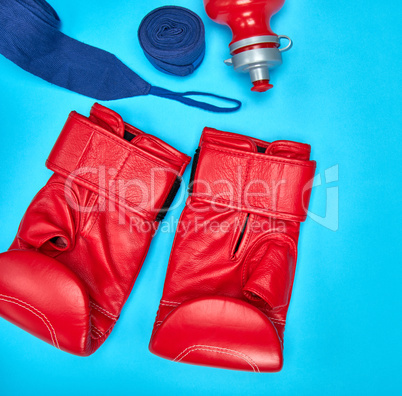pair of red leather boxing gloves and a textile bandage
