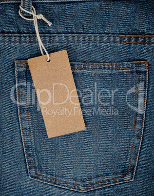 empty rectangular brown paper tag on blue jeans