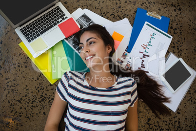 Woman lying on documents in office