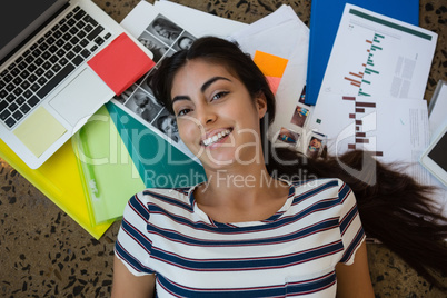 Woman lying on documents at office