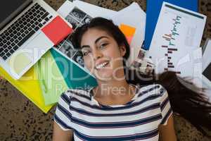 Woman lying on documents at office