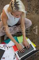 Woman using laptop on floor at office