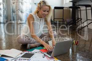 Woman using laptop on floor at office