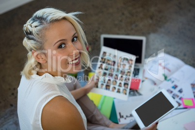 Woman holding document and digital tablet at office