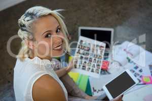 Woman holding document and digital tablet at office