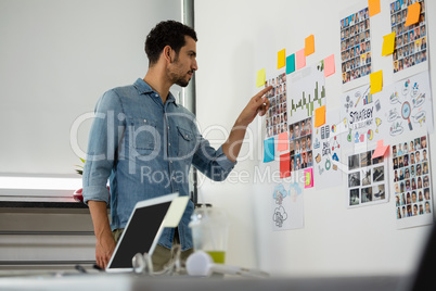 Man pointing at photographs in office