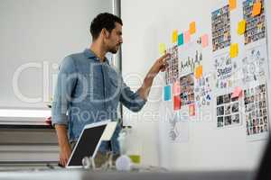 Man pointing at photographs in office