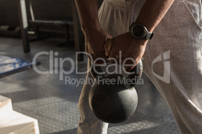 Senior man exercising with kettle bells in the fitness studio