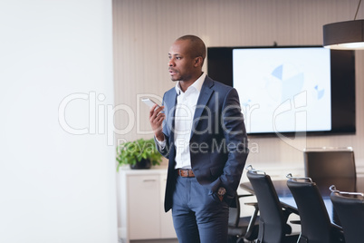 Businessman speaking at mobile phone standing in the office