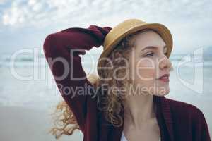 Beautiful Caucasian woman standing with a hat on beach