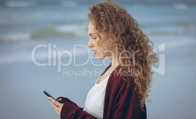 Woman using mobile phone at beach