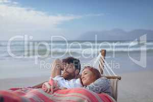 Couple relaxing on hammock at beach