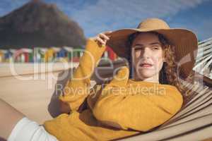 Woman lying on hammock at beach