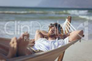 Man relaxing on hammock at beach