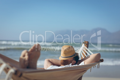 Man relaxing on hammock at beach