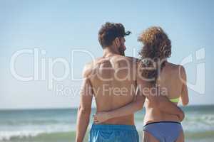 Couple standing with arm around at beach
