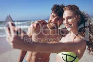Couple taking selfie standing at beach