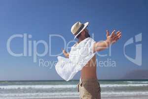 Happy man standing with open arm at beach