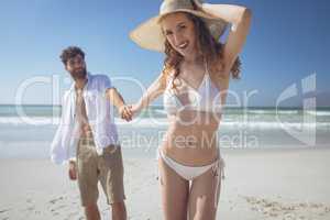 Couple holding hand while standing at beach