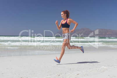 Young woman running at beach on a sunny day