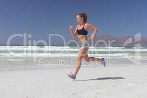 Young woman running at beach on a sunny day