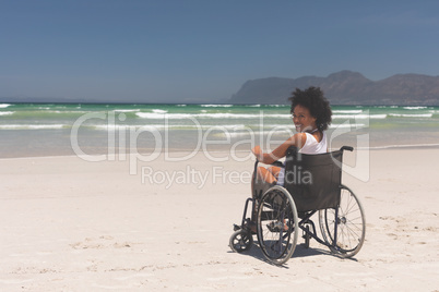 Young woman disable sitting on wheelchair at beach