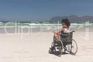 Young woman disable sitting on wheelchair at beach