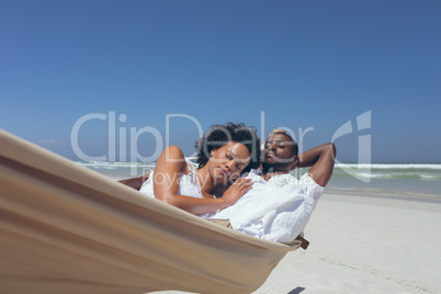 Young couple relaxing on hammock at beach