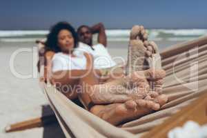 Young couple relaxing on hammock at beach