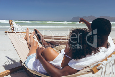 Young couple relaxing on hammock at beach