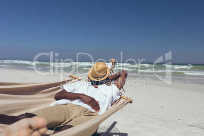 Man sleeping on hammock at beach