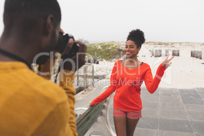 Man capturing photo of woman while standing at pavement