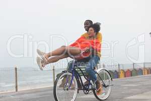 Couple enjoying at bicycle while riding at pavement