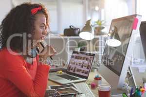 Female graphic designer working on desktop pc at desk