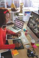 Female graphic designer using graphic tablet at desk