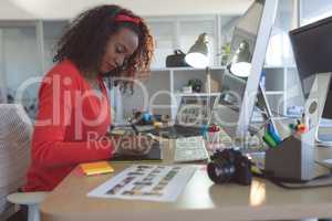 Female graphic designer using graphic tablet at desk