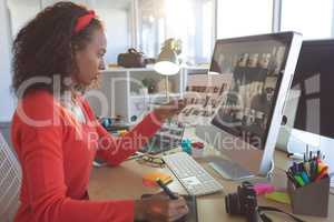 Attentive female graphic designer working at desk