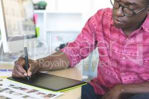 Graphic designer working on graphic tablet at desk